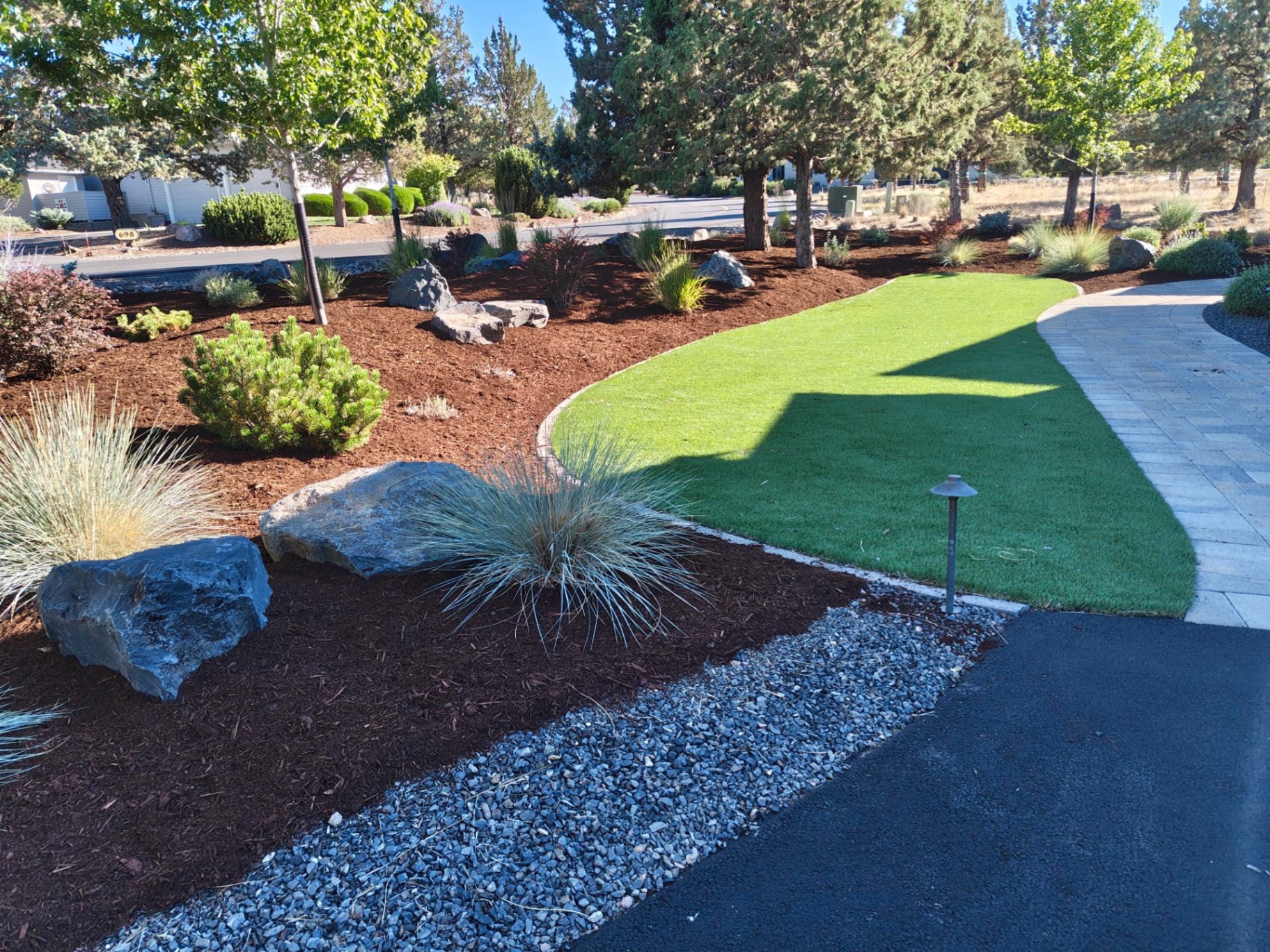 Artificial turf lawn with paver walkway, boulder accents and mulch beds in a Bend Oregon front yard in Bend, OR by A1 Lawn & Landscape of Bend